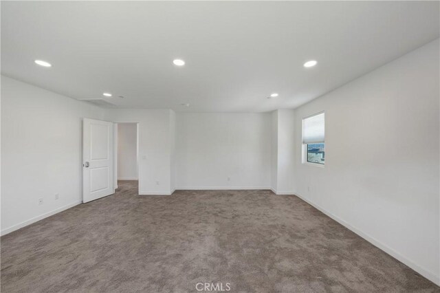 empty room with carpet floors, baseboards, and recessed lighting