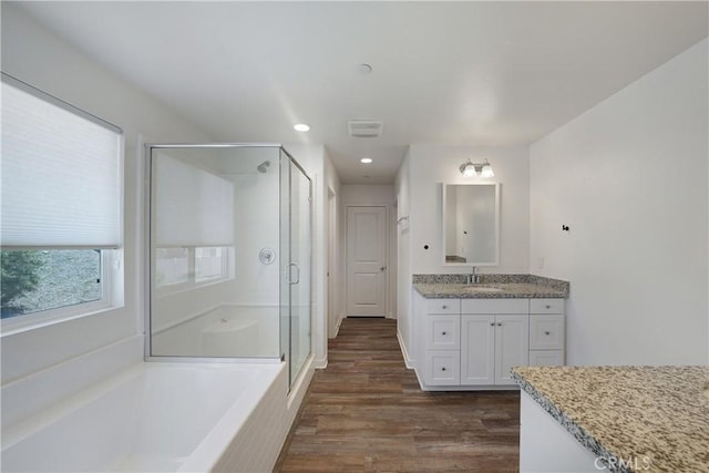full bathroom with vanity, recessed lighting, a shower stall, a bath, and wood finished floors