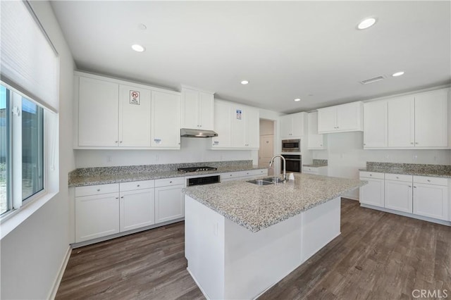 kitchen featuring dark wood finished floors, white cabinetry, appliances with stainless steel finishes, under cabinet range hood, and a sink