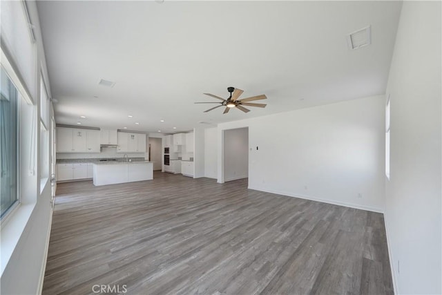 unfurnished living room with light wood-type flooring, a ceiling fan, visible vents, and recessed lighting