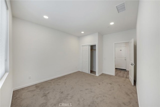 unfurnished bedroom featuring a closet, baseboards, recessed lighting, carpet flooring, and visible vents