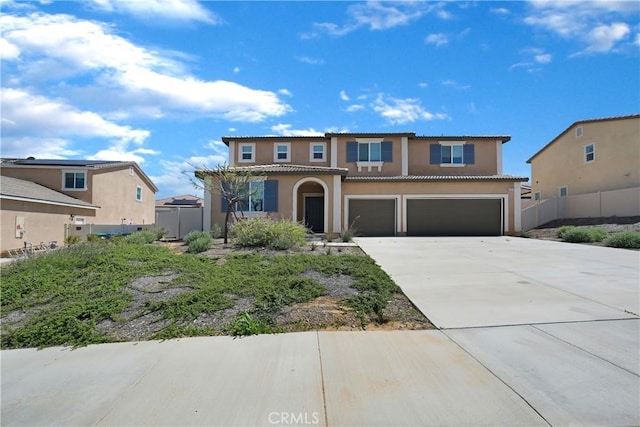 view of front of home featuring a tiled roof, an attached garage, fence, stucco siding, and driveway