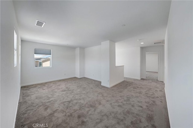 carpeted empty room with baseboards and visible vents