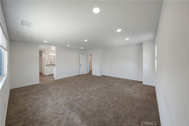 empty room featuring visible vents, baseboards, carpet floors, and recessed lighting