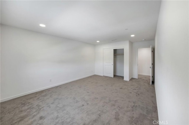 unfurnished bedroom featuring carpet, baseboards, recessed lighting, and a closet