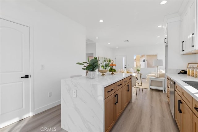8491 Emerado Pl, Westminster, CA 92683 - kitchen featuring white cabinets, light stone counters, dishwasher, light wood-style floors, and a kitchen island