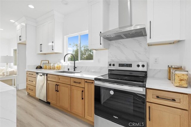 8491 Emerado Pl, Westminster, CA 92683 - kitchen featuring light wood finished floors, wall chimney range hood, a sink, decorative backsplash, and appliances with stainless steel finishes
