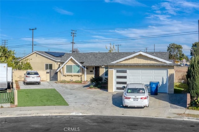 8491 Emerado Pl, Westminster, CA 92683 - ranch-style home featuring driveway, fence, roof mounted solar panels, a front yard, and stucco siding