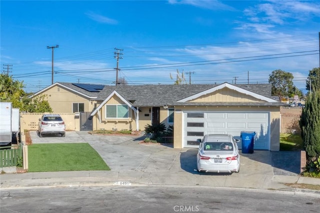8491 Emerado Pl, Westminster, CA 92683 - view of front of property featuring concrete driveway, a front lawn, fence, stucco siding, and solar panels