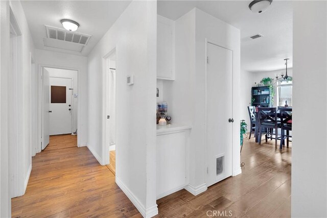 13564 Sylvan Oaks Rd, Victorville, CA 92392 - corridor featuring visible vents, baseboards, and light wood-style flooring