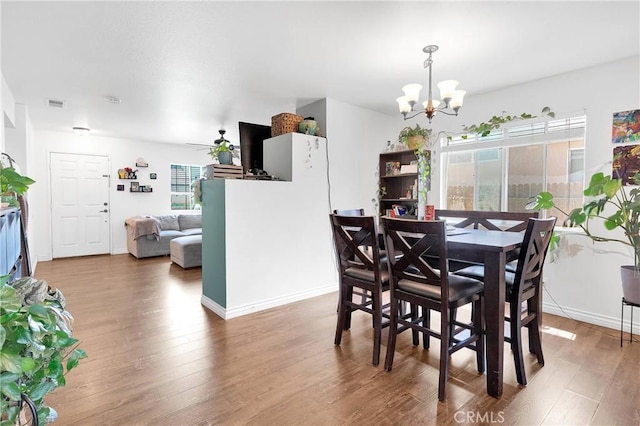 13564 Sylvan Oaks Rd, Victorville, CA 92392 - dining space featuring a notable chandelier, visible vents, wood finished floors, and a healthy amount of sunlight