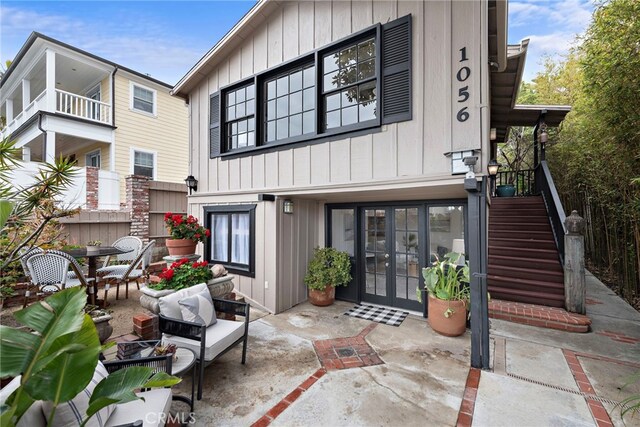 1056 Glenneyre St, Laguna Beach, CA 92651 - rear view of property with french doors, a patio, stairs, and board and batten siding