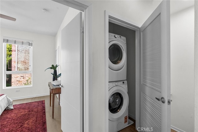 5643 Cielo Way, Los Angeles, CA 90028 - laundry area featuring stacked washer and clothes dryer, wood finished floors, and baseboards