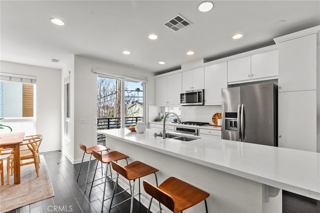 5643 Cielo Way, Los Angeles, CA 90028 - kitchen featuring stainless steel appliances, a sink, recessed lighting, baseboards, and a breakfast bar