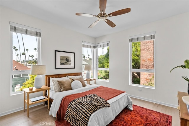 5643 Cielo Way, Los Angeles, CA 90028 - bedroom featuring multiple windows, wood finished floors, baseboards, and ceiling fan