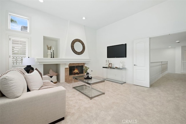 living area featuring a tile fireplace, baseboards, carpet, and recessed lighting