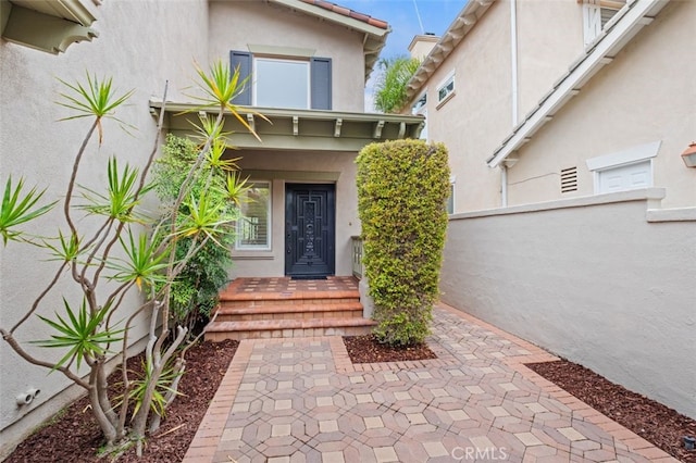 view of exterior entry with stucco siding