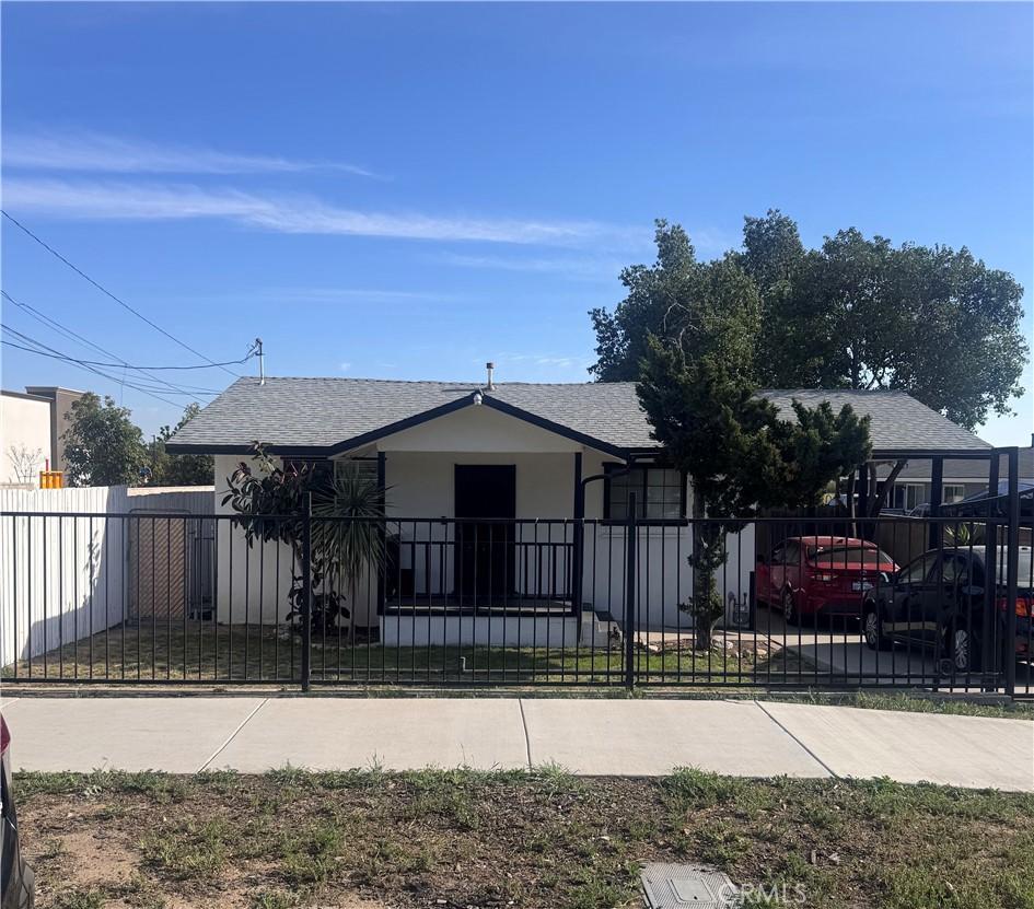 135 W Randall Ave, Rialto, CA 92376 - view of front facade featuring roof with shingles, stucco siding, and a fenced front yard
