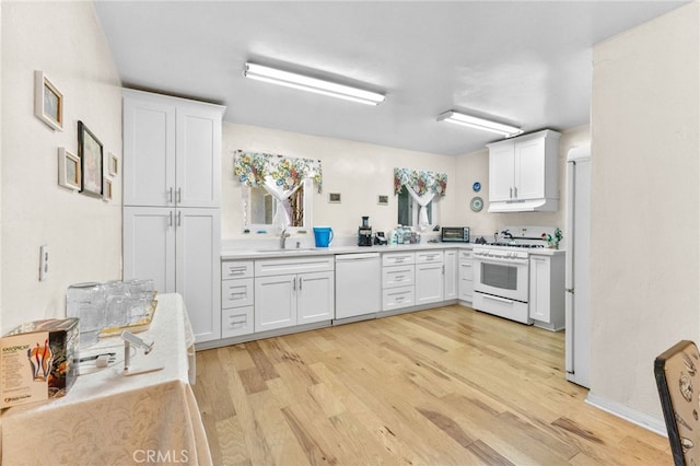 266 N 14th St, Banning, CA 92220 - kitchen with white appliances, a sink, under cabinet range hood, light wood-style floors, and white cabinetry