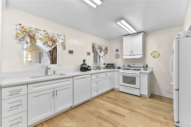 266 N 14th St, Banning, CA 92220 - kitchen featuring white appliances, a sink, under cabinet range hood, white cabinetry, and light wood-type flooring