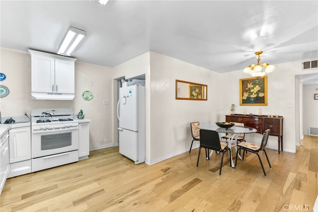 266 N 14th St, Banning, CA 92220 - kitchen with white appliances, under cabinet range hood, light countertops, light wood-type flooring, and white cabinetry