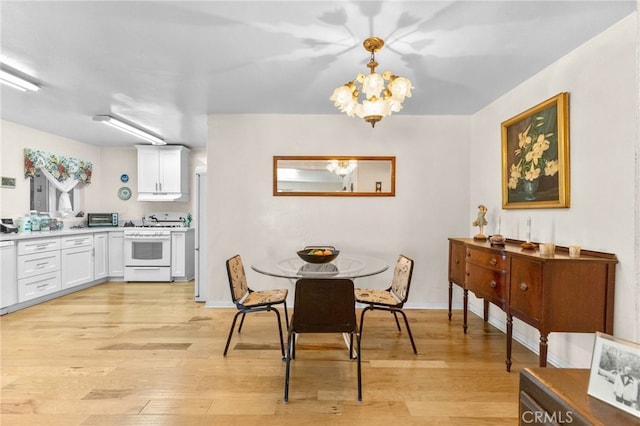 266 N 14th St, Banning, CA 92220 - dining area with light wood finished floors, a chandelier, and baseboards