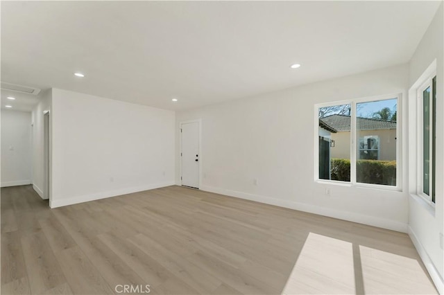 unfurnished room featuring baseboards, light wood finished floors, and recessed lighting