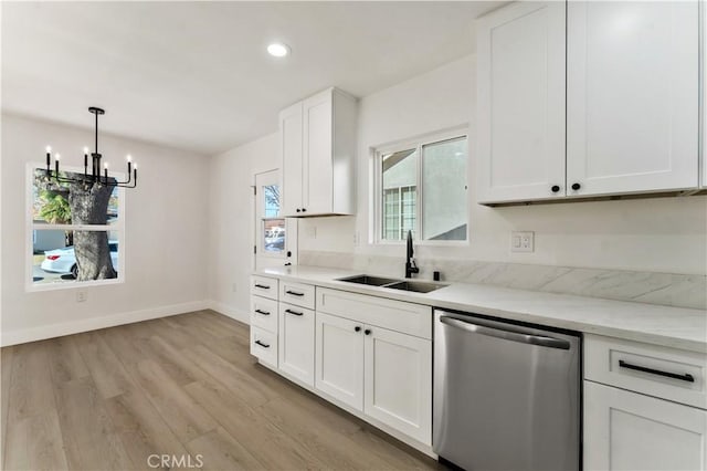 kitchen featuring baseboards, an inviting chandelier, a sink, light wood-type flooring, and stainless steel dishwasher