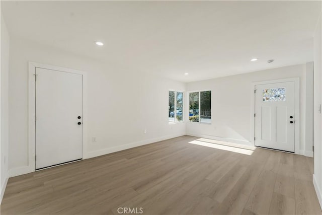 foyer featuring light wood-style flooring, recessed lighting, and baseboards
