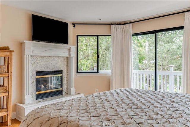 2180 Benson Ave, Cambria, CA 93428 - bedroom with a premium fireplace, access to exterior, and wood finished floors