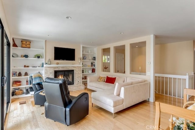 2180 Benson Ave, Cambria, CA 93428 - living area with light wood finished floors, built in features, and a warm lit fireplace