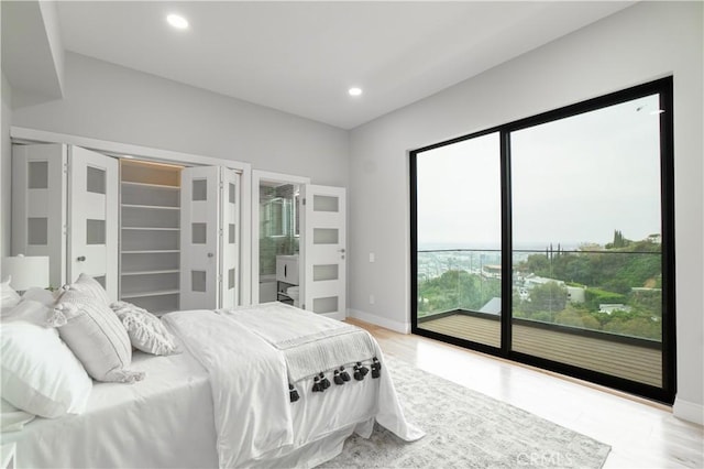 bedroom with access to outside, light wood finished floors, baseboards, and recessed lighting