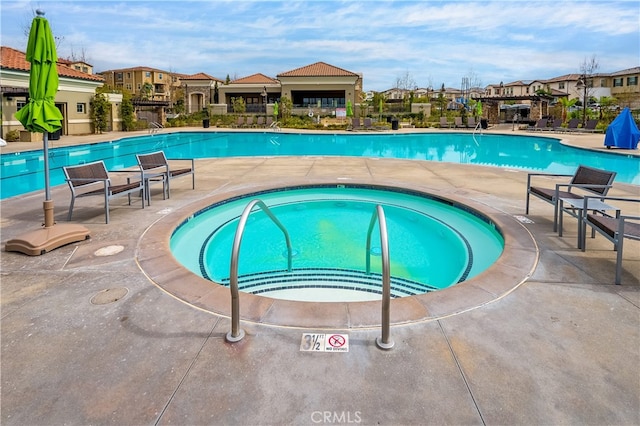 community pool featuring a residential view and a patio