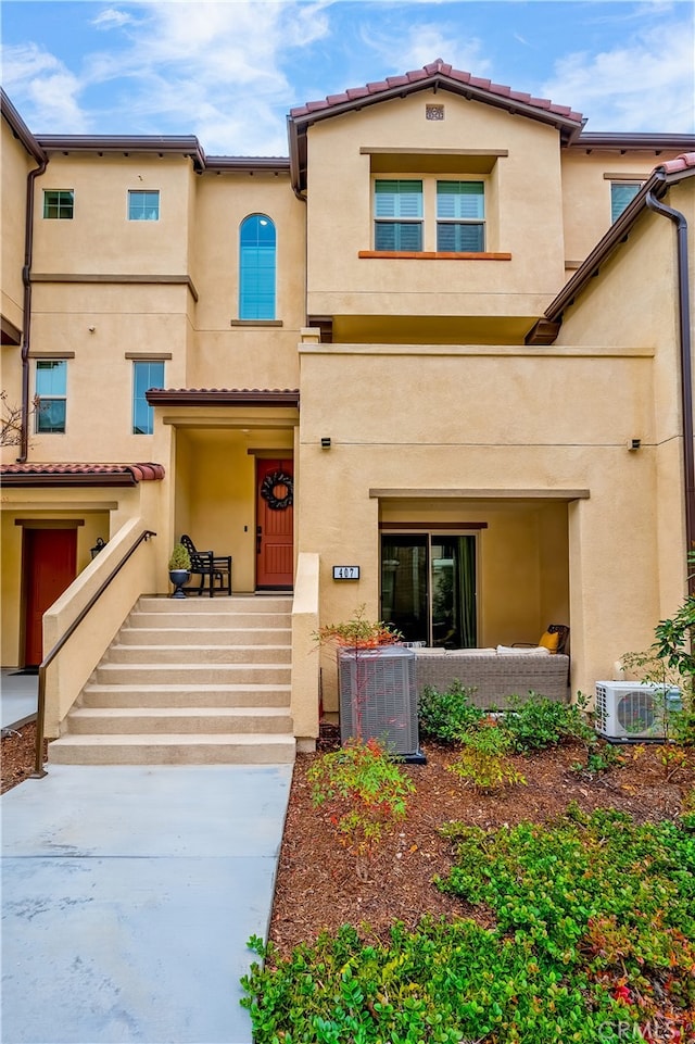 view of front of house featuring central air condition unit, ac unit, and stucco siding