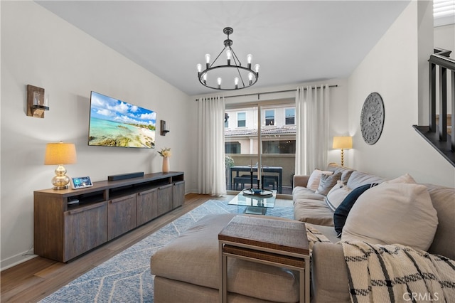 living room with baseboards, wood finished floors, and a chandelier