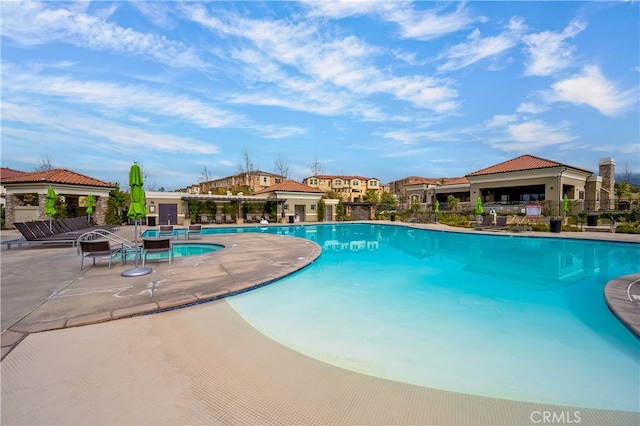 community pool with fence and a patio