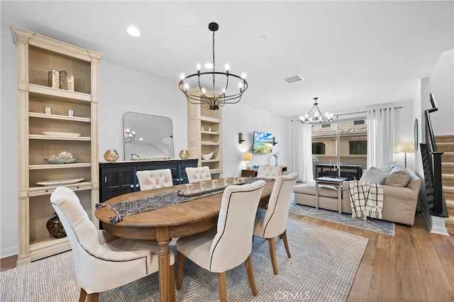 dining room featuring recessed lighting, visible vents, light wood-style floors, a chandelier, and stairs