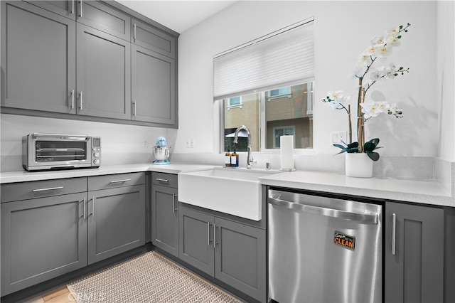 kitchen with dishwasher, a toaster, a sink, and gray cabinets