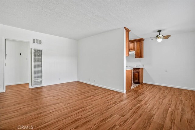 1101 E Ocean Blvd Unit 14, Long Beach, CA 90802 - unfurnished living room featuring a heating unit, a textured ceiling, light wood-style floors, ceiling fan, and visible vents