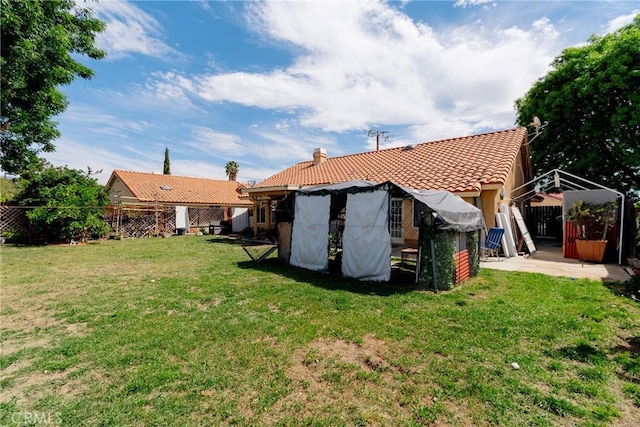 25351 Chicago Ave, Hemet, CA 92544 - back of house with stucco siding, fence, a tile roof, and a lawn