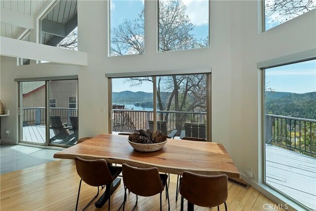 27637 St Bernard Ln, Lake Arrowhead, CA 92352 - dining room featuring visible vents, light wood finished floors, a towering ceiling, and a mountain view