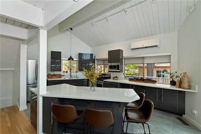 27637 St Bernard Ln, Lake Arrowhead, CA 92352 - kitchen with a kitchen bar, visible vents, appliances with stainless steel finishes, a wall mounted air conditioner, and vaulted ceiling with beams