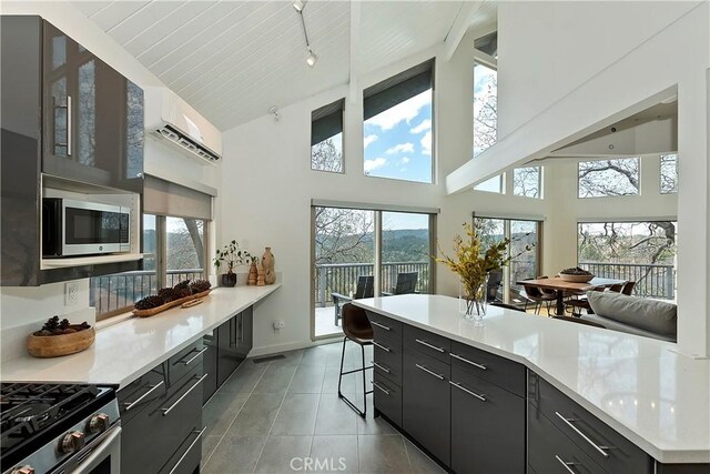 27637 St Bernard Ln, Lake Arrowhead, CA 92352 - kitchen with light countertops, stainless steel microwave, light tile patterned floors, and a kitchen bar