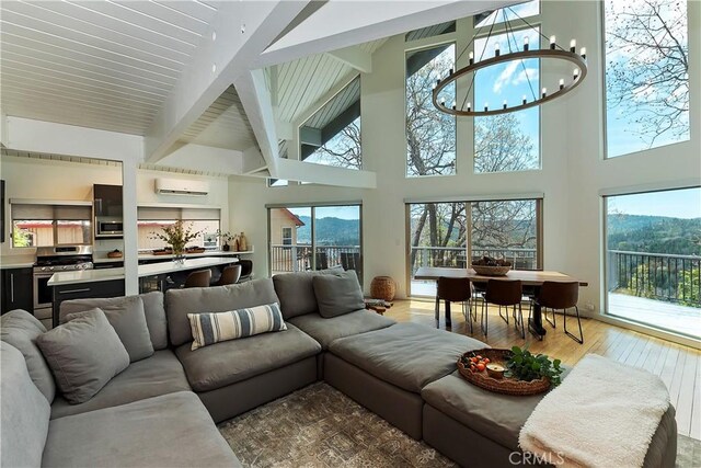 27637 St Bernard Ln, Lake Arrowhead, CA 92352 - living room with beam ceiling, a wall mounted air conditioner, high vaulted ceiling, a mountain view, and hardwood / wood-style floors