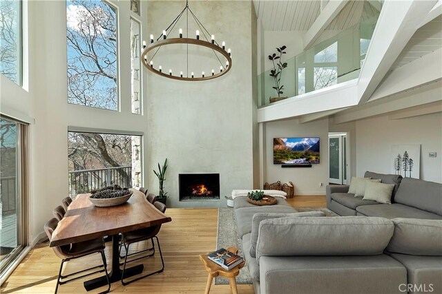 27637 St Bernard Ln, Lake Arrowhead, CA 92352 - living area with an inviting chandelier, wood finished floors, beam ceiling, high vaulted ceiling, and a high end fireplace