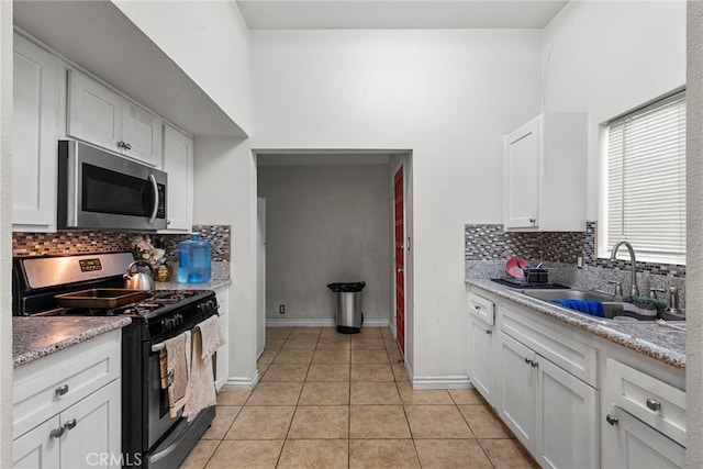 2619 Trinity St, Los Angeles, CA 90011 - kitchen featuring appliances with stainless steel finishes, a sink, decorative backsplash, and white cabinets