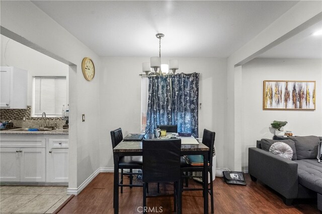 2619 Trinity St, Los Angeles, CA 90011 - dining space with a chandelier, wood finished floors, and baseboards