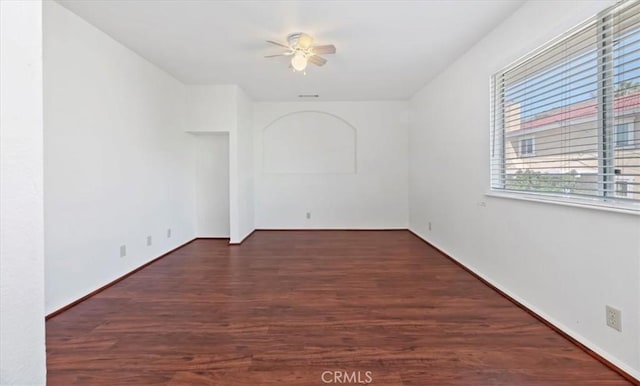 unfurnished room with visible vents, wood finished floors, and ceiling fan