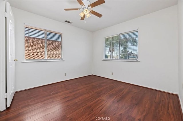 unfurnished room with wood finished floors, ceiling fan, baseboards, and visible vents