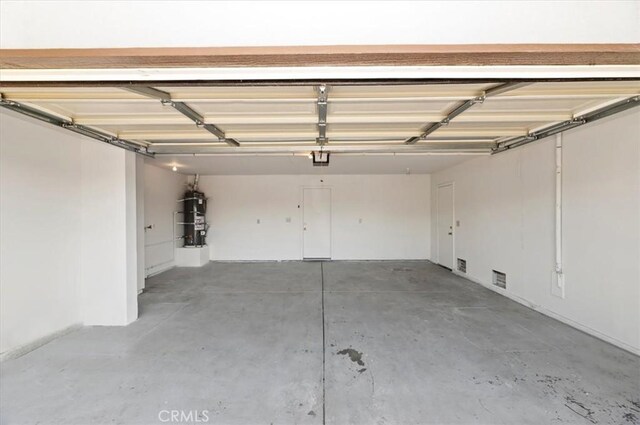 garage with a garage door opener and water heater